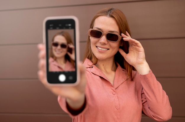 Foto mujer caucásica tomando un selfie con su smartphone