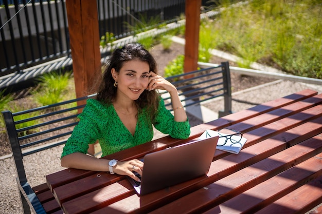 Mujer caucásica trabajando con computadora portátil fuera de la oficina