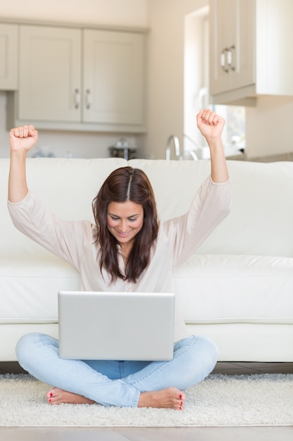 Foto mujer celebrando frente a la computadora portátil