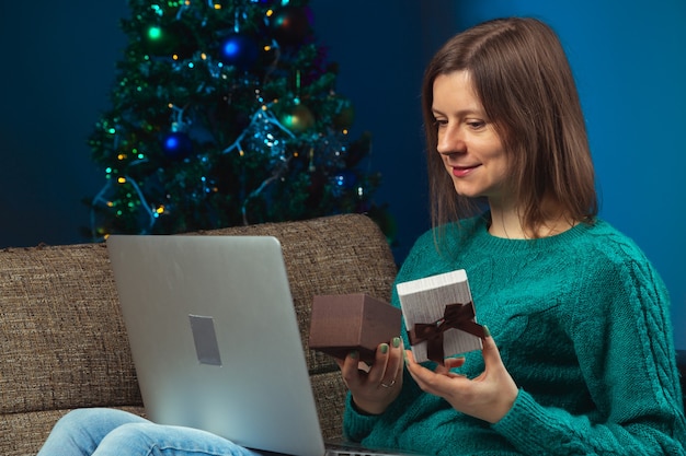 Mujer celebrando la víspera de Navidad con familiares por teléfono Felicitaciones de año nuevo pandémico