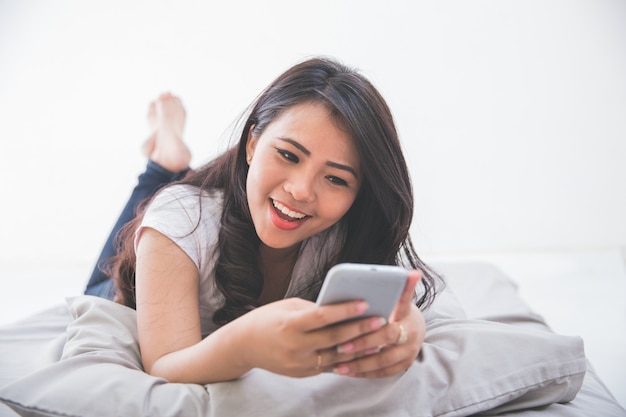 Mujer con celular en la cama