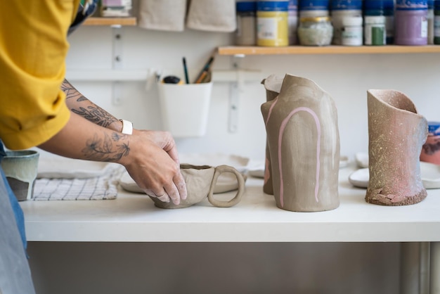 Mujer ceramista haciendo taza en estudio mujer trabajando con arcilla durante la clase magistral de cerámica