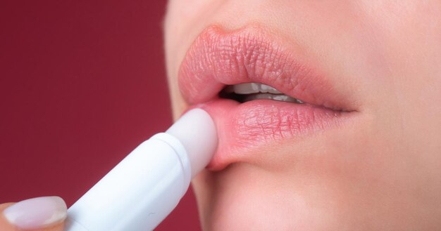 Mujer de cerca aplicando lápiz labial rojo en los labios Chica sexy aplicando lápliz labial maquillaje de lápiz labio rojo Poniendo lápiz lipstick en los labius