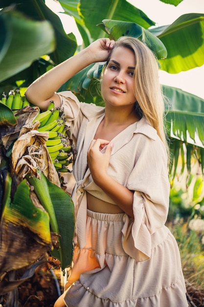 Mujer cerca de una gran hoja verde de árbol de plátano en la naturaleza en el parque Plantas tropicales