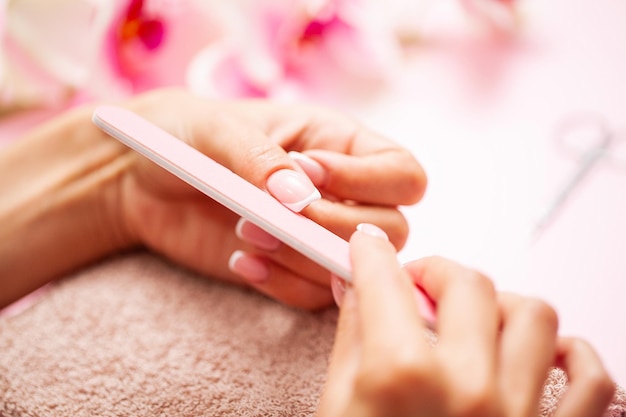 Mujer de cerca haciendo manicura en casa.