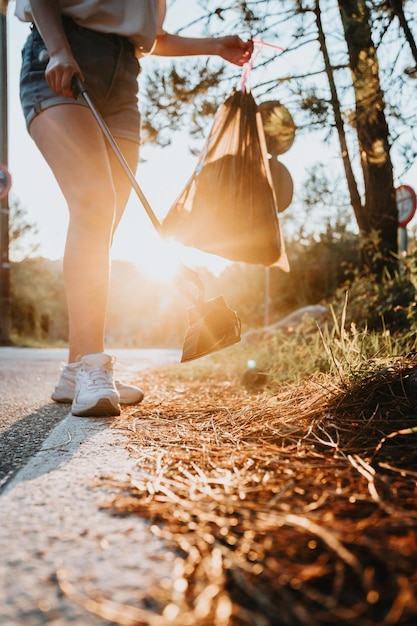 Mujer de cerca limpiando desfile natural de plásticos al atardecer con basura manteniendo nuestros parques limpios feliz día ecológico Naturaleza limpieza ecología concepto verde Espacio de copia de medio ambiente sostenible