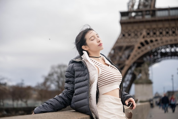 Mujer cerca de la torre Eiffel en un día de invierno