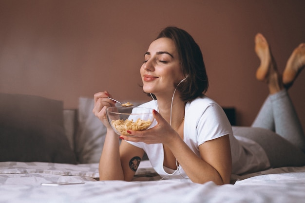 Foto mujer con cereales y auriculares