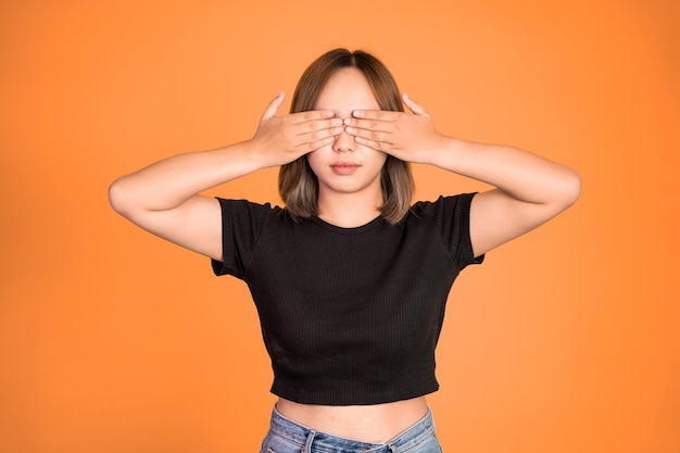 Mujer cerrando los ojos con ambas palmas sobre fondo aislado