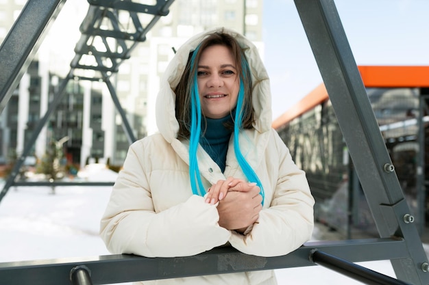 Mujer con chaqueta blanca y cabello azul.