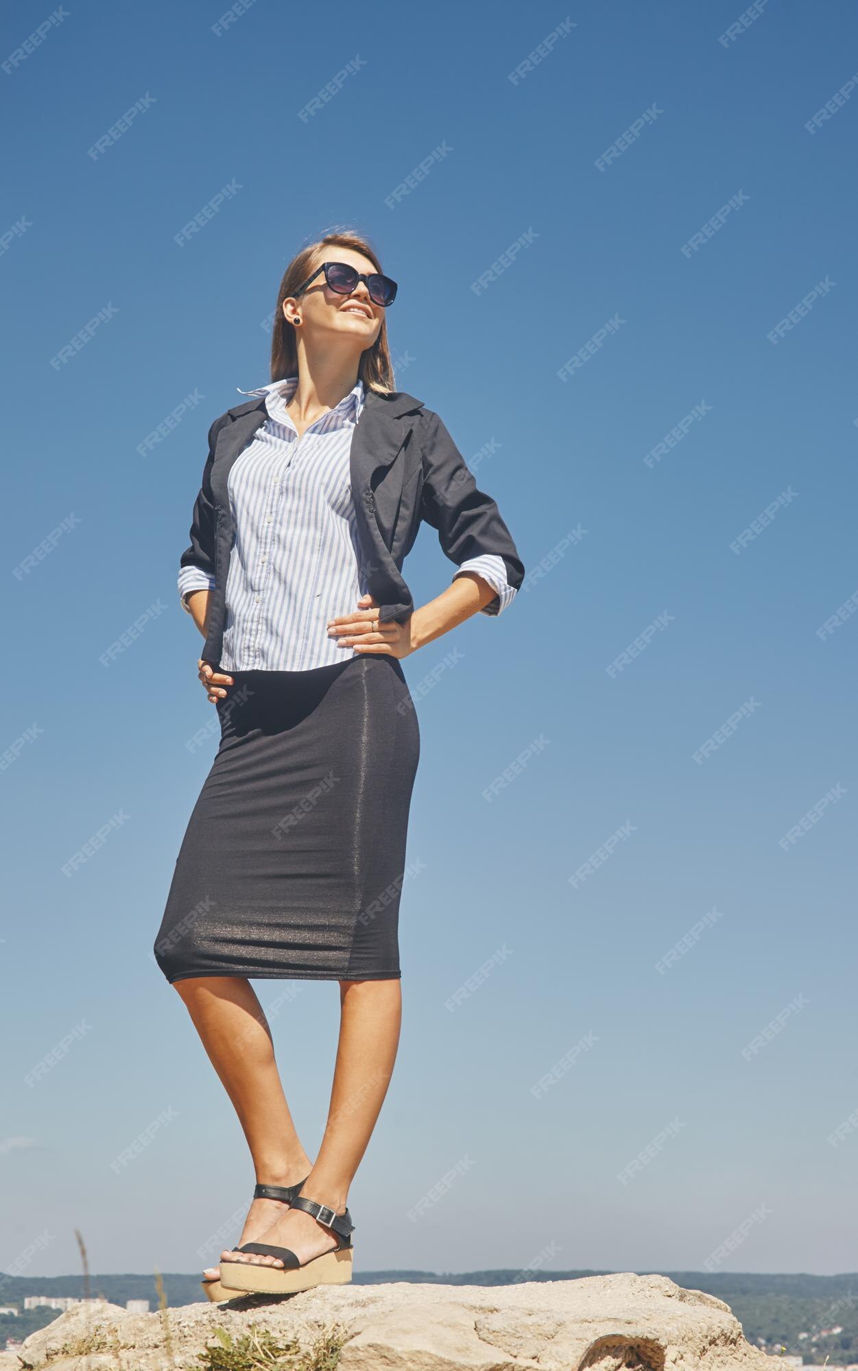 con chaqueta de manga corta, blusa blanca y falda negra hasta la rodilla con gafas de sol | Foto Premium