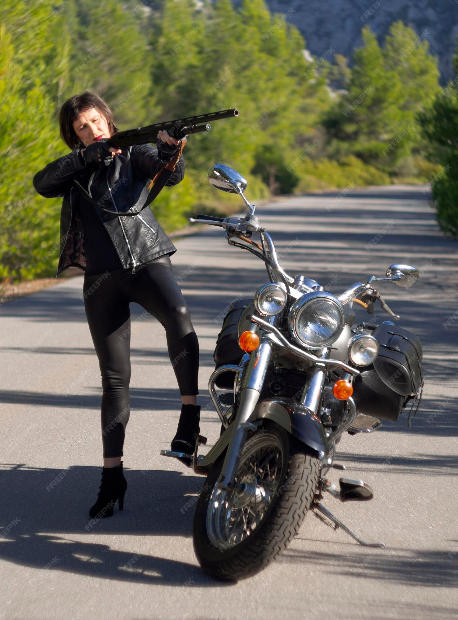 sábado Júnior sensor Una mujer con una chaqueta de motociclista de cuero negro con un rifle de  carabina en una motocicleta chopper en grecia | Foto Premium