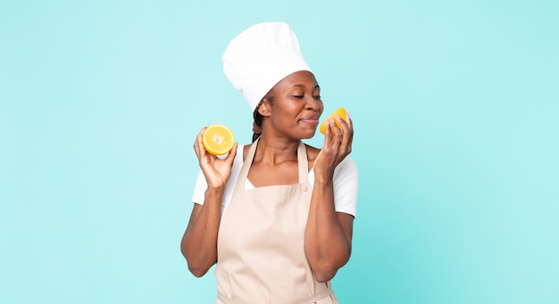 Mujer chef adulta afroamericana negra. concepto de jugo de naranja