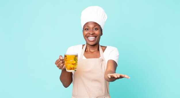 Mujer de chef adulto afroamericano negro con una pinta de cerveza