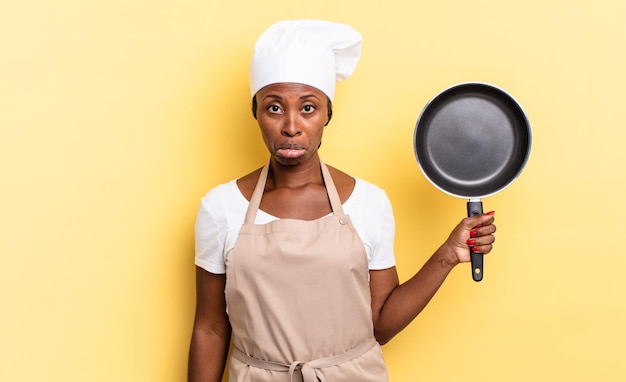 Mujer chef afro negra que se siente triste y quejumbrosa con una mirada infeliz llorando con una actitud negativa y frustrada