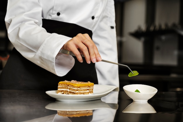 Mujer chef en la cocina preparando el postre