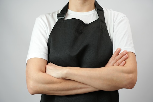 Foto la mujer chef lleva un delantal con los brazos cruzados.