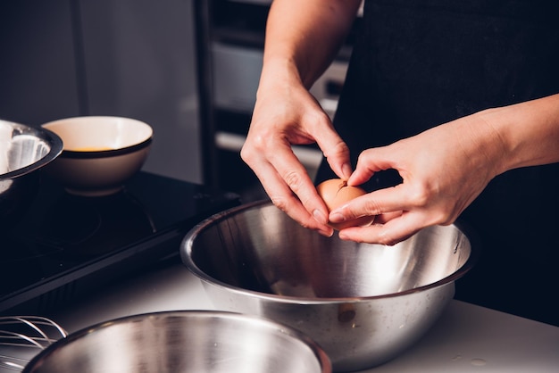 Mujer chica panadero en la cocina cocina batir huevo