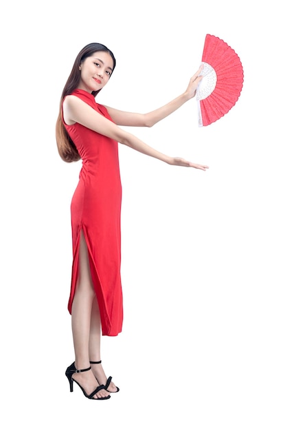 Mujer china asiática en un vestido cheongsam sosteniendo un ventilador con la palma abierta mostrando algo aislado sobre fondo blanco.