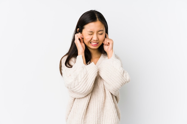 Mujer China joven aislado coning orejas con las manos.