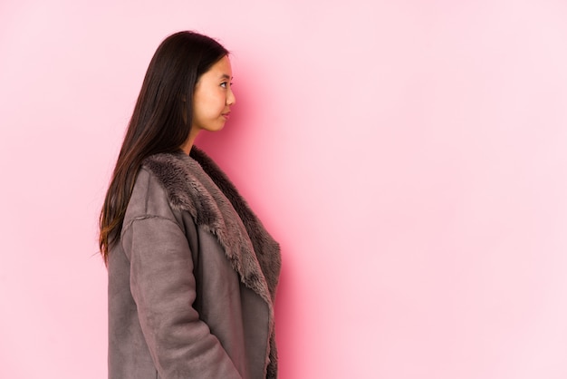 Foto la mujer china joven que llevaba un abrigo aisló mirar la actitud izquierda, oblicua.