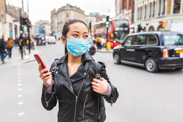 Mujer china en Londres con mascarilla para protegerse del smog y el virus