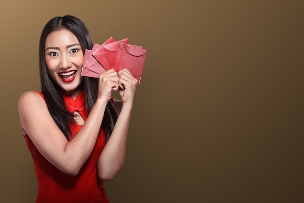 Mujer china en ropa tradicional sosteniendo angpao.