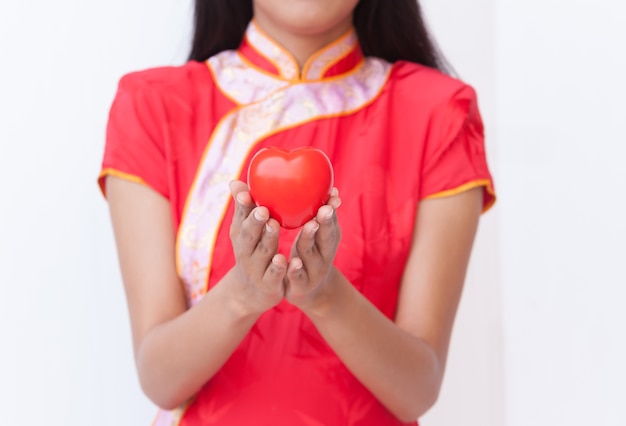 Foto mujer china, tenencia, corazón rojo
