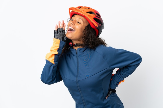 Mujer ciclista adolescente aislada en blanco gritando con la boca abierta hacia el lado