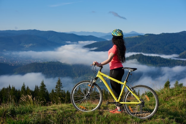 mujer ciclista con bicicleta amarilla