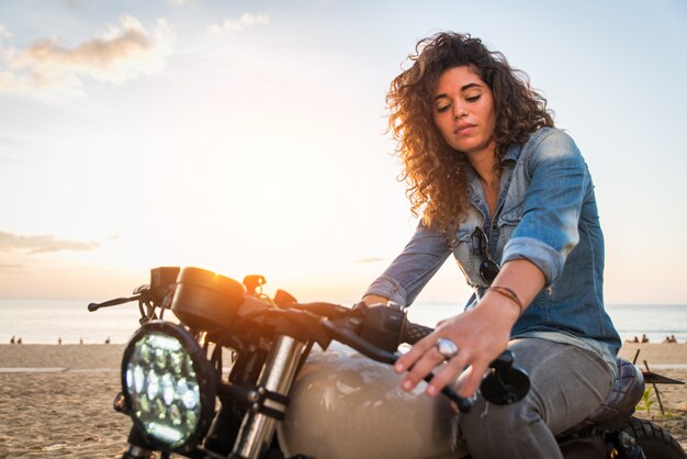 Mujer ciclista conduciendo una moto cafe racer