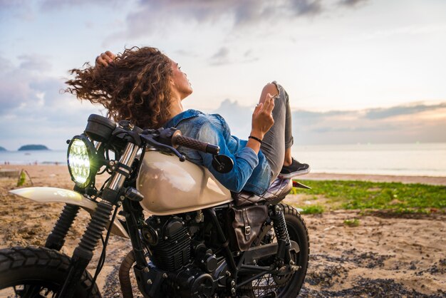 Mujer ciclista conduciendo una moto cafe racer