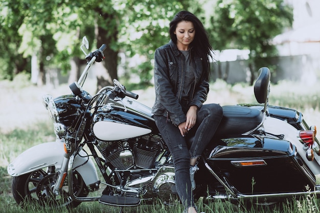 mujer ciclista está sentado en su motocicleta en un día soleado de verano