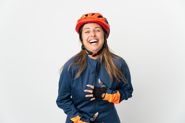 Mujer ciclista de mediana edad aislada en la pared blanca sonriendo mucho