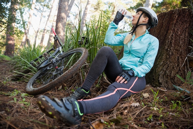 Mujer ciclista de montaña agua potable