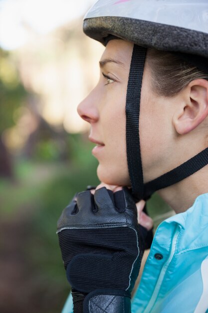 Mujer ciclista de montaña con casco de bicicleta