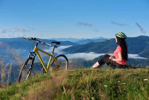 Mujer ciclista montando en bicicleta en las montañas