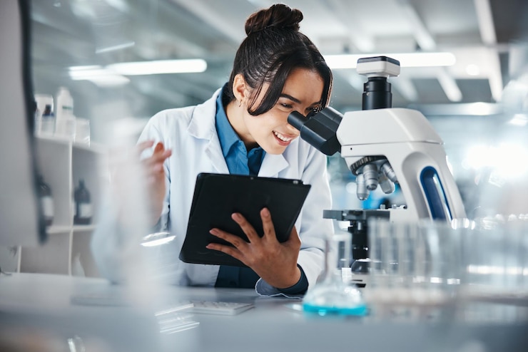 Foto mujer científica y microscopio con tableta en el laboratorio para la investigación de experimentos datos médicos e información científica investigadora de sonrisas y digital para el estudio de biotecnología, retroalimentación y solución de vacunas