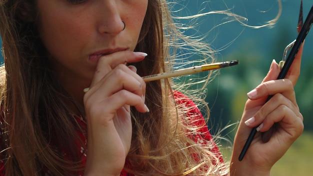 Foto una mujer con un cigarrillo en la boca.