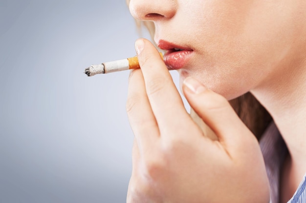 Mujer con cigarrillo exhalando humo
