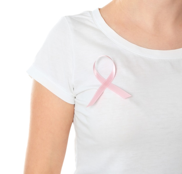 Mujer con cinta rosa en camiseta contra la superficie blanca, primer plano. Concepto de concienciación sobre el cáncer de mama