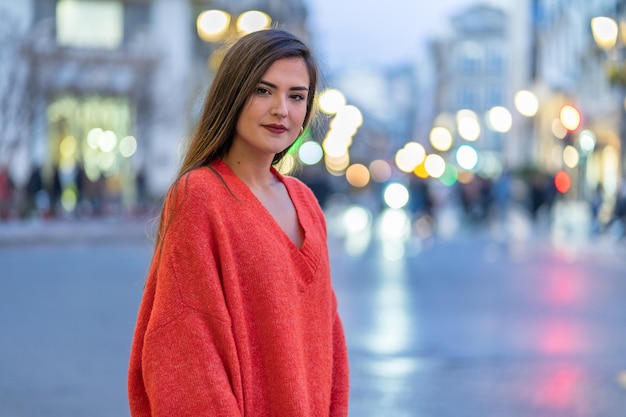 Mujer en la ciudad con las luces de fondo.