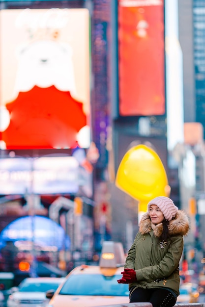 Mujer de la ciudad de Nueva York en Times Square. Hermosa joven sonriente feliz en Manhattan, Ciudad de Nueva York, Nueva York, Estados Unidos.