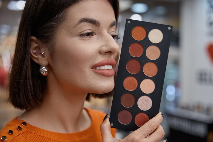 Foto mujer cliente eligiendo rubor facial sosteniéndolo cerca de la cara