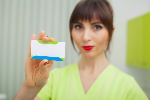 Mujer en clínica dental con tarjetas en blanco