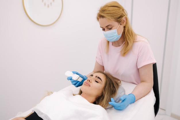 La mujer en la clínica de spa de belleza cosmética tiene cosmetología de hardware facial