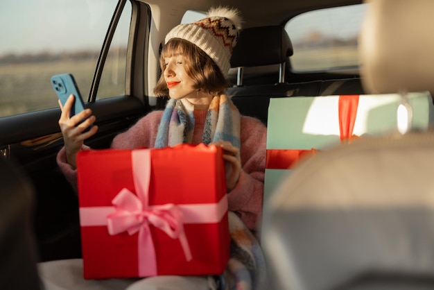 Mujer en coche con regalos de navidad