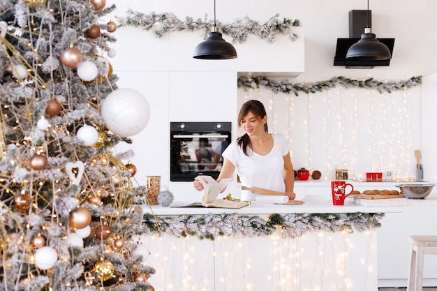 Mujer cocina en la cocina en el año nuevo en casa