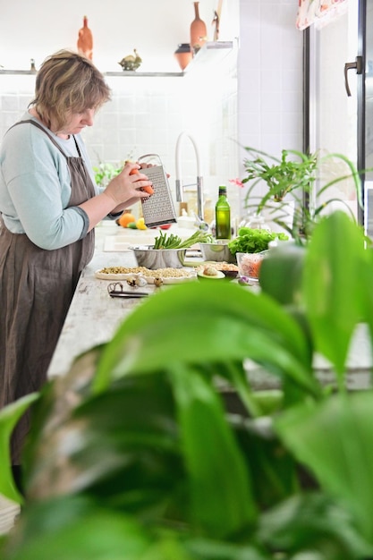 Mujer cocina comida vegetariana para mascotas en el interior