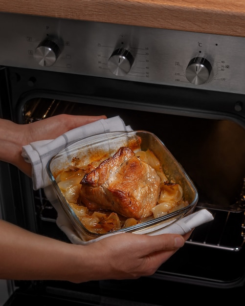 Foto la mujer cocina el guiso y lo saca del horno. preparación de comida casera. dieta proteica, dieta cetogénica